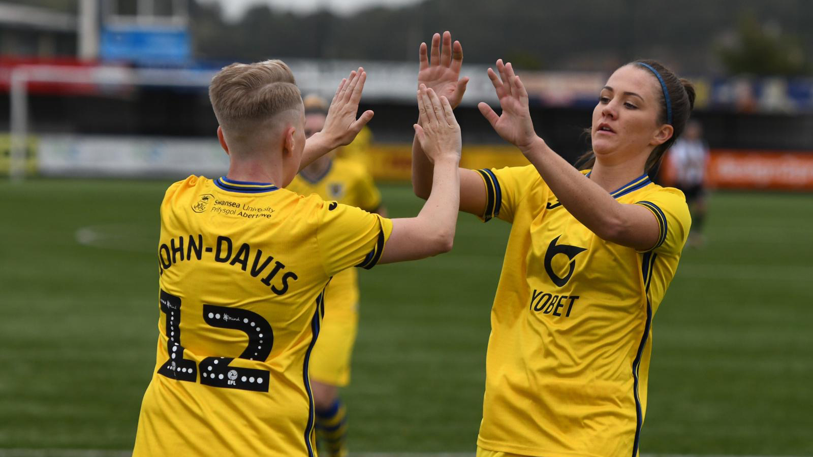 Stacey John-Davis and Emma Beynon celebrate a goal.