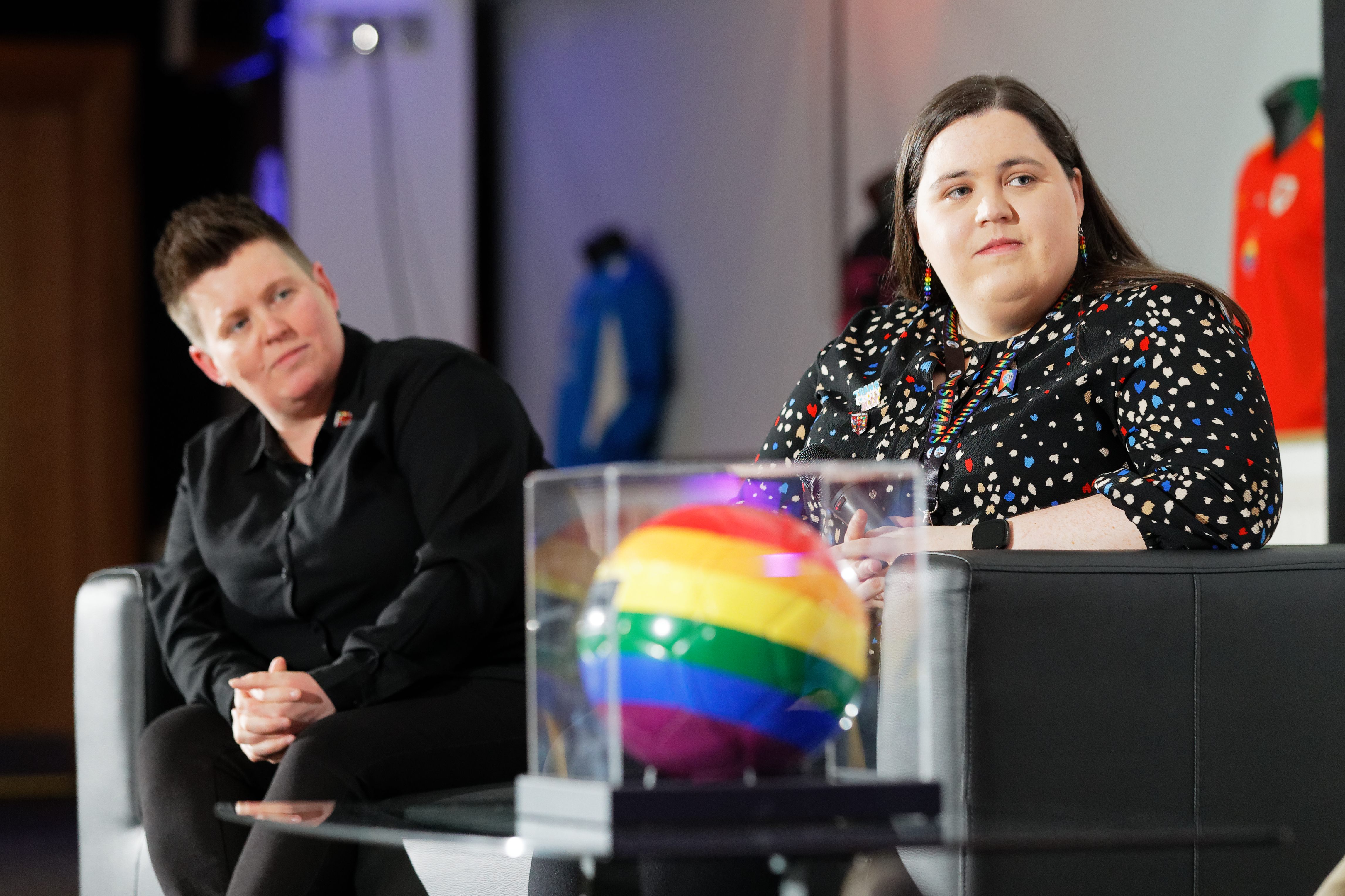 Carys and one other panelist sitting on a sofa at the Proud Together event