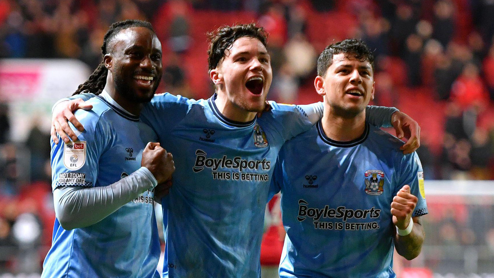  Coventry City football club players celebrating a goal, they are wearing blue shirts with white shorts and socks.