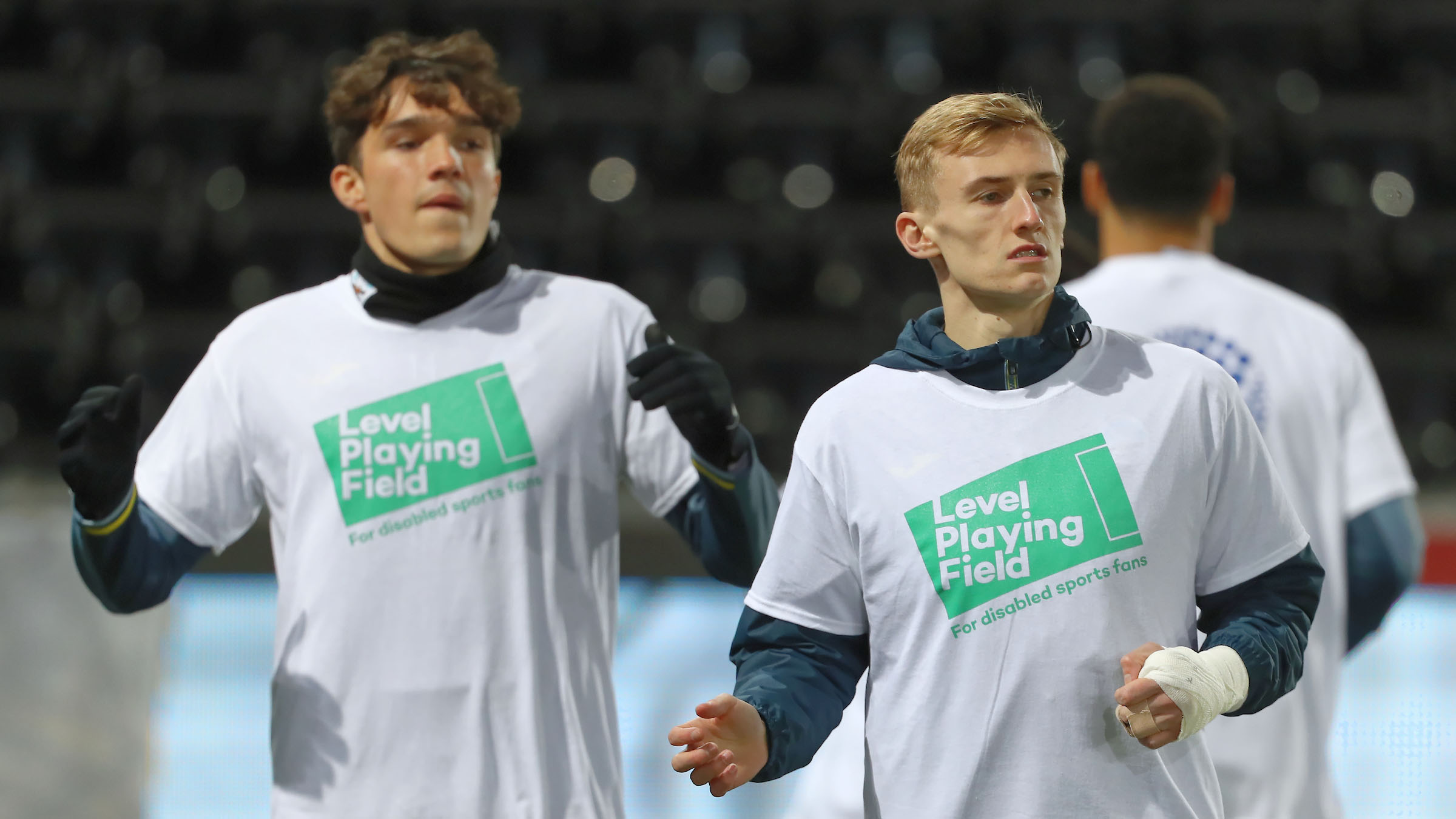 Players warm up in Level Playing Field t-shirts