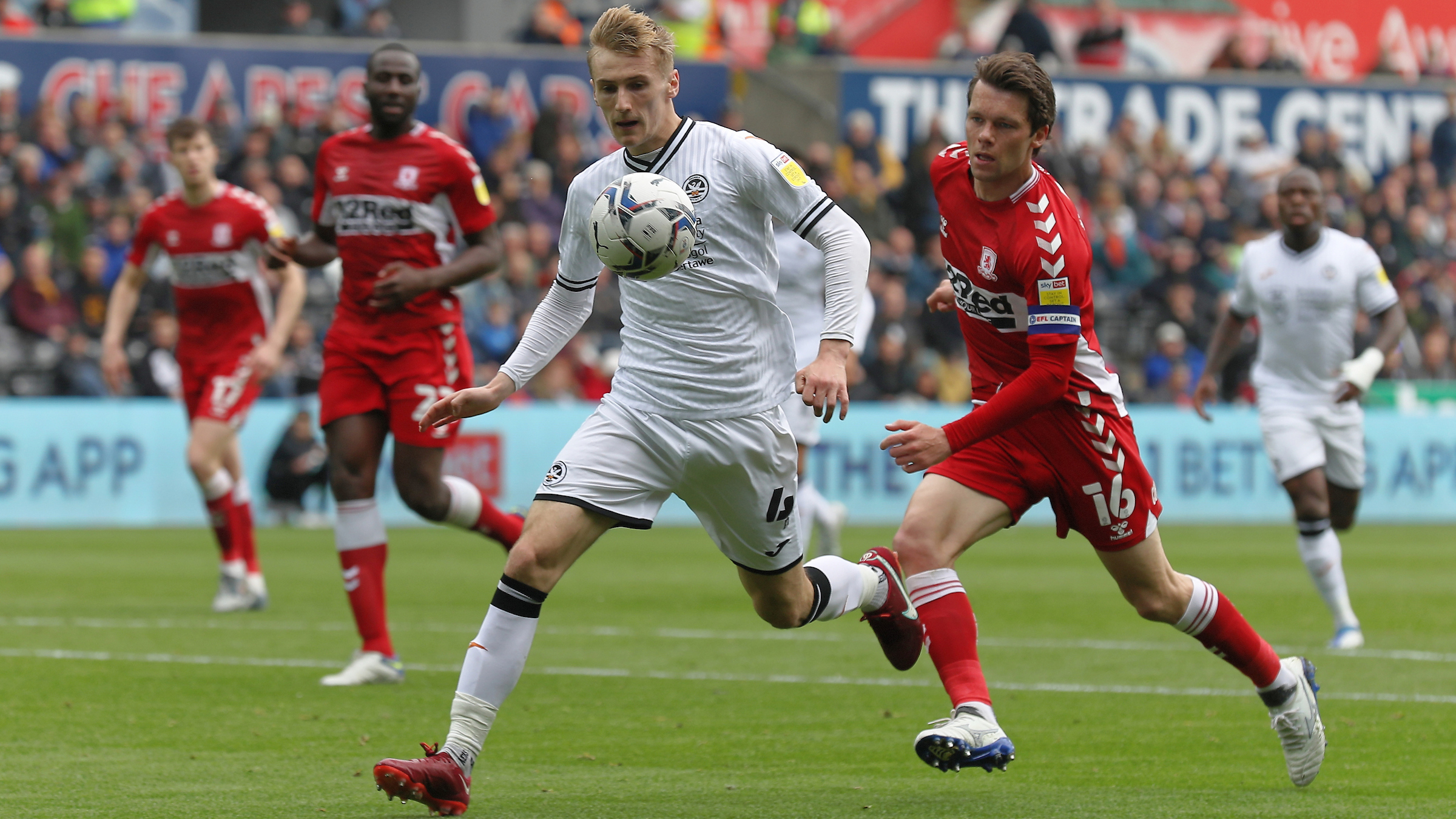 Flynn Downes controls a ball under pressure from Middlesbrough player