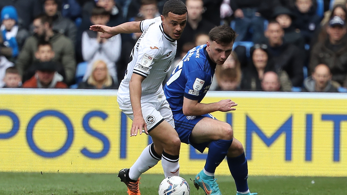 Joel Latibeaudiere challenges for a ball with Mark Harris