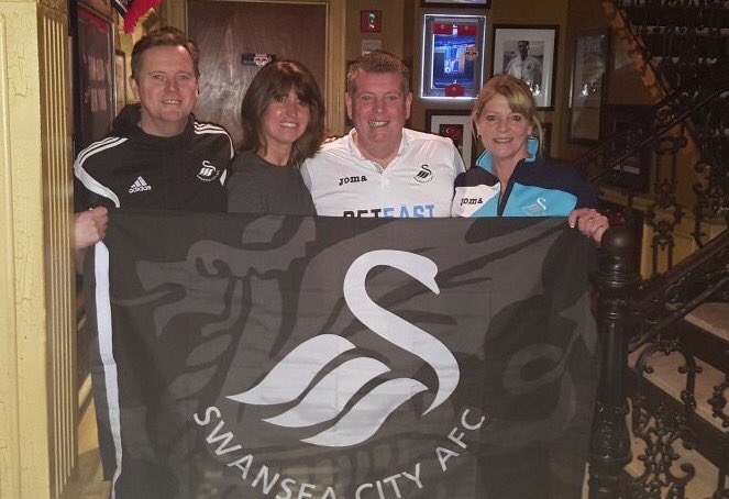 The James brothers on holiday with their wives and Swansea City flag