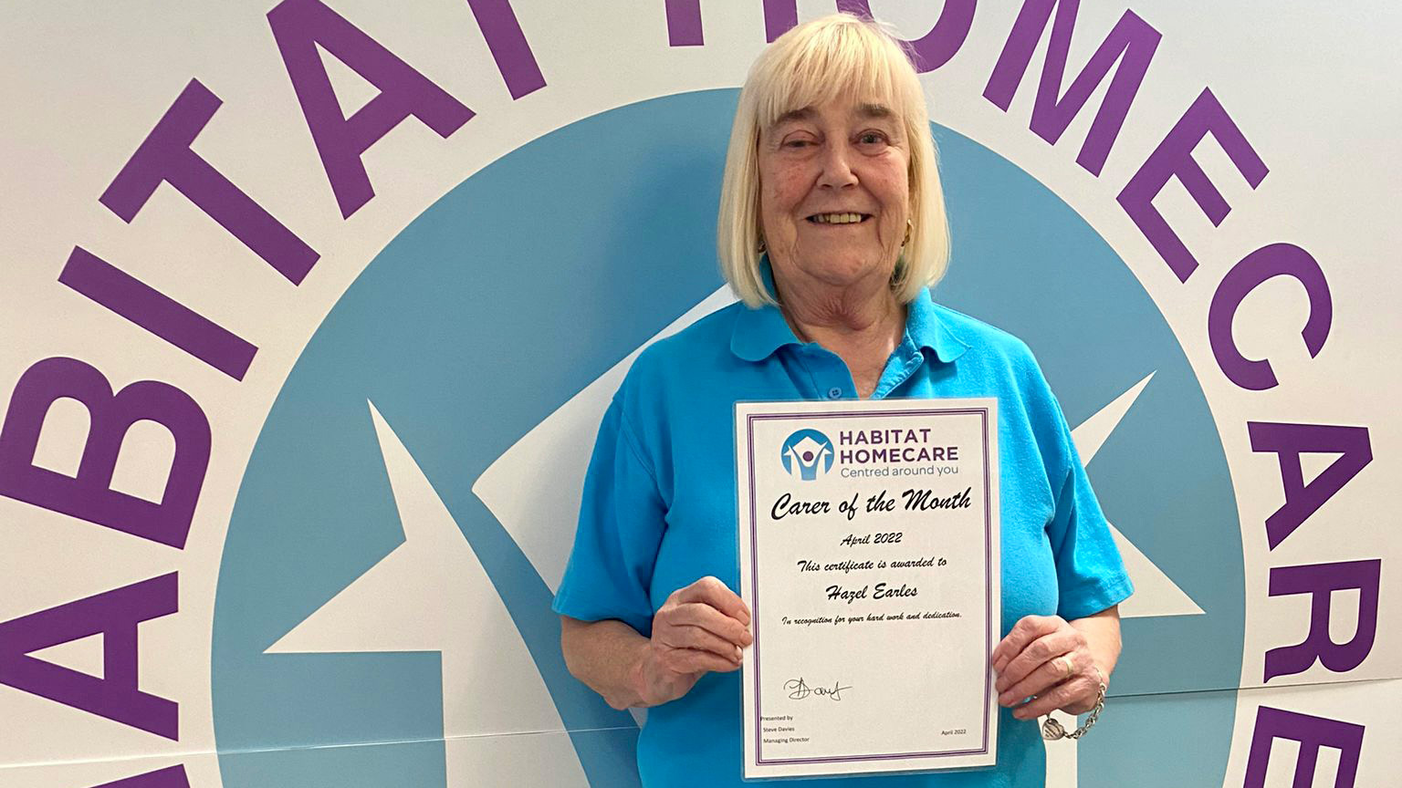 Hazel holds up her Carer of the Month certificate