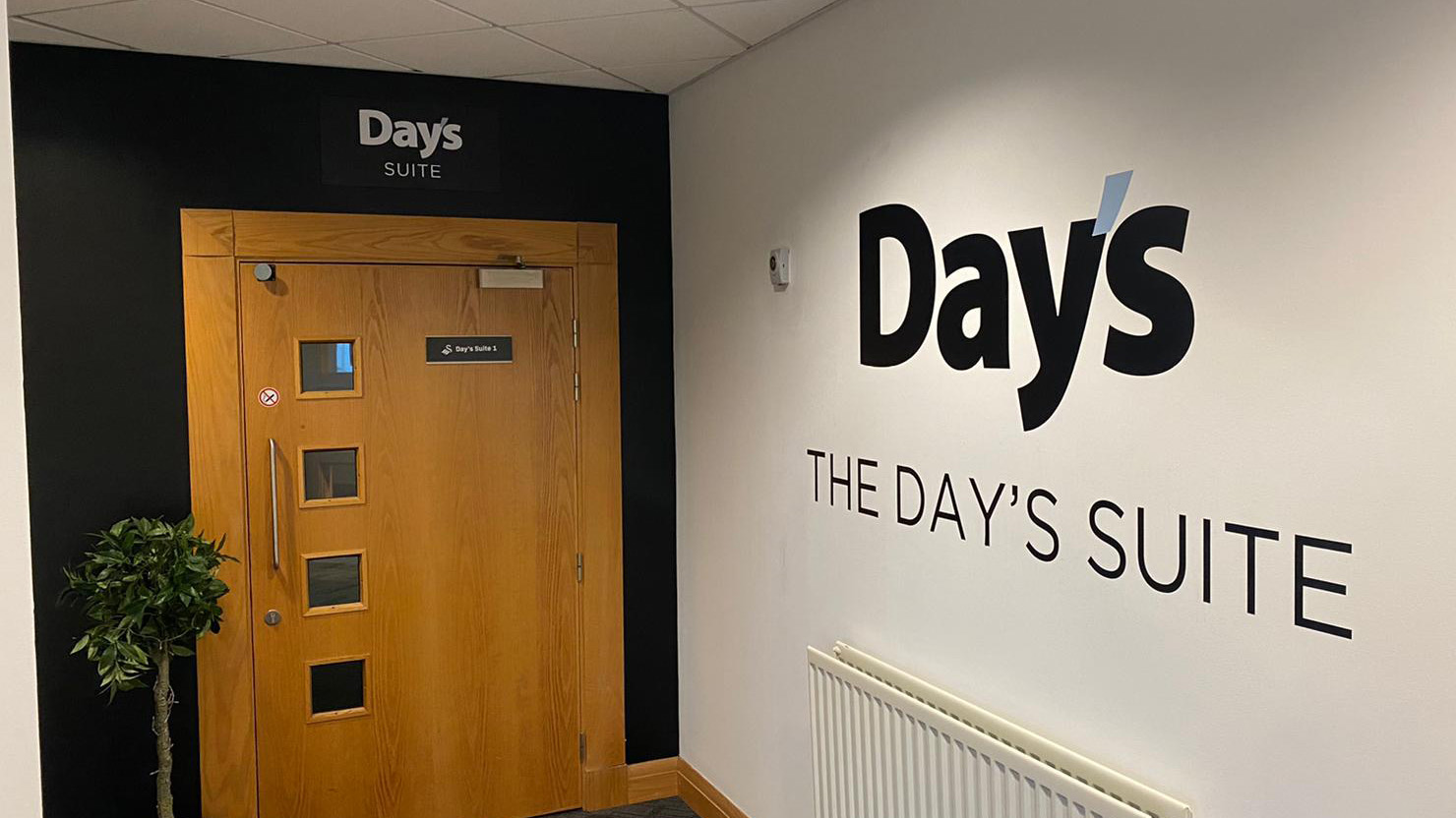 A photo of the entrance to the Day's Suite with the Day's Suite branding on the wall