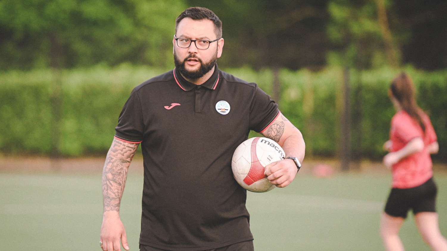 Swansea City ladies head coach Jon Beale holding a football and taking a training session 