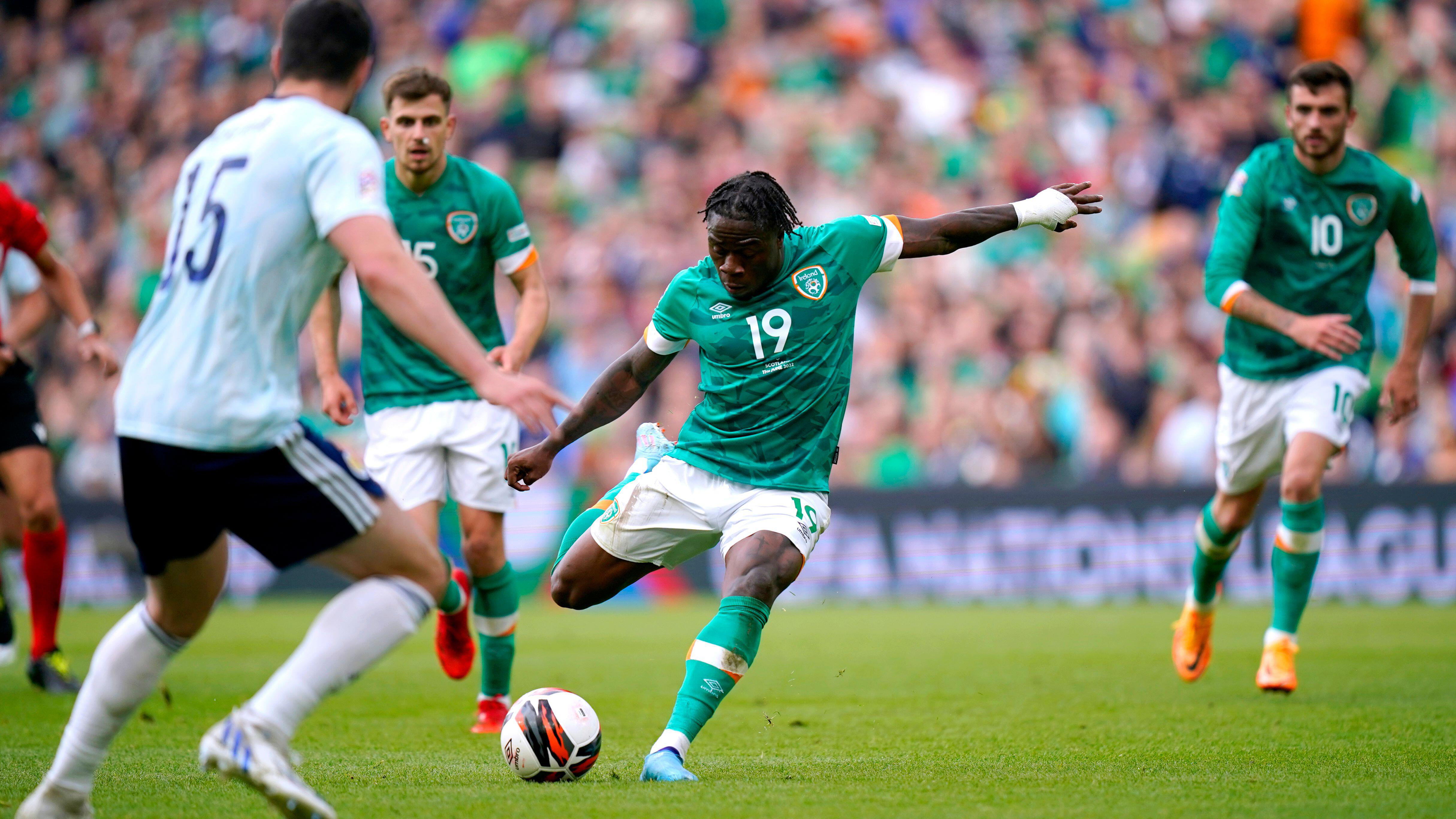 Michael Obafemi - in green Ireland home kit - about to strike a ball right footed 