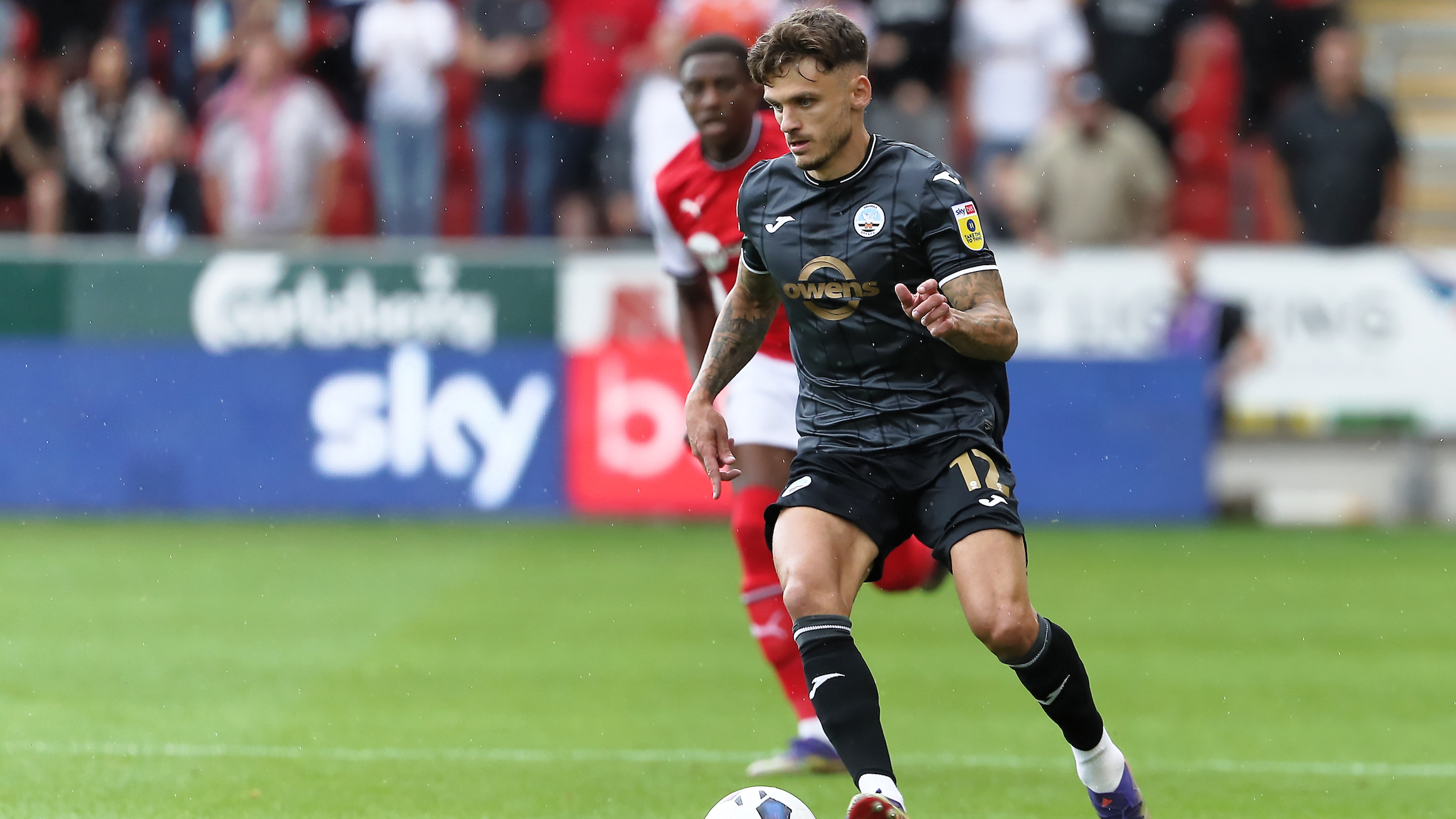 Jamie Paterson in the grey third kit running with the ball