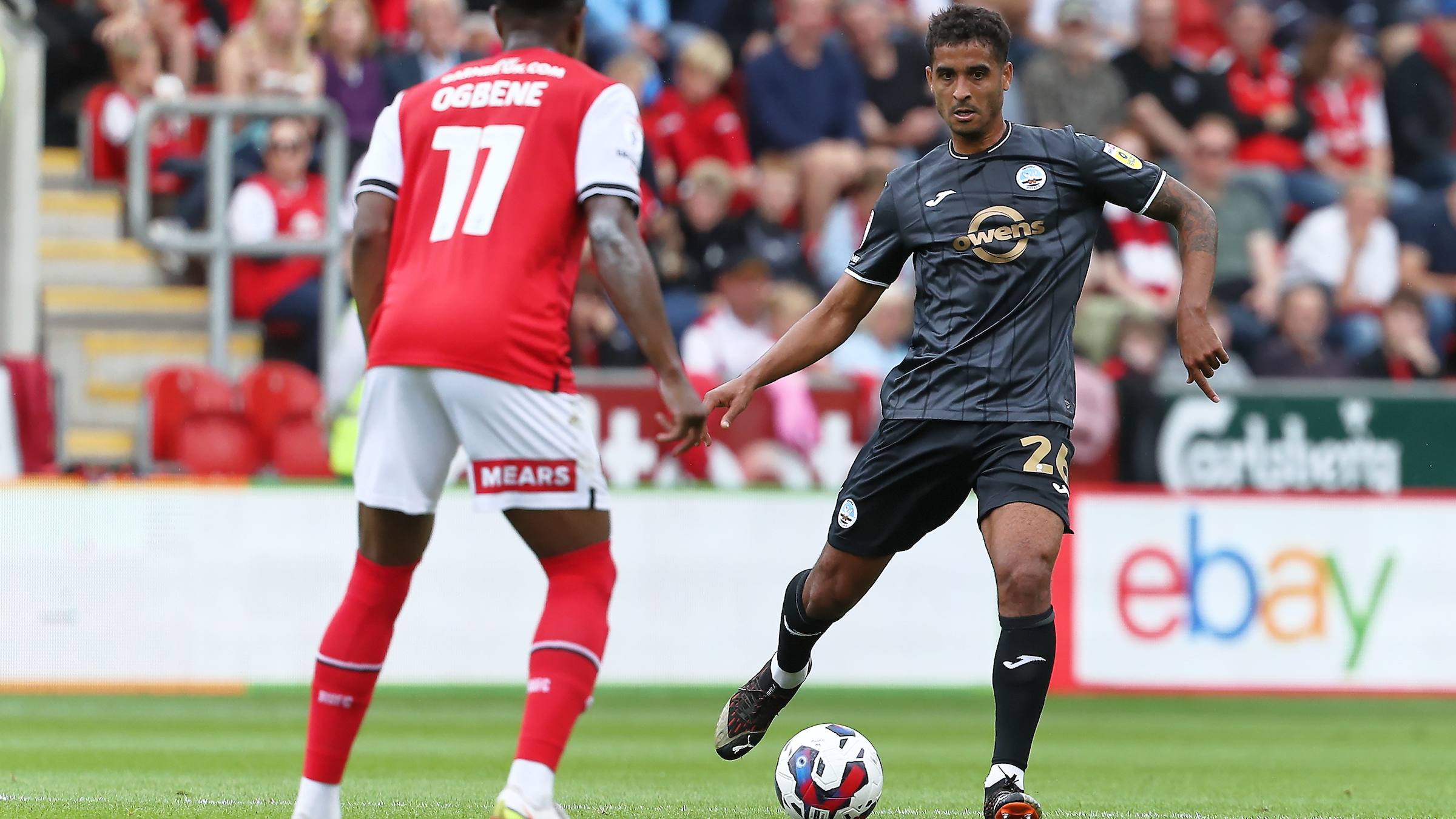 Kyle Naughton on the ball under pressure from a Rotherham player. 