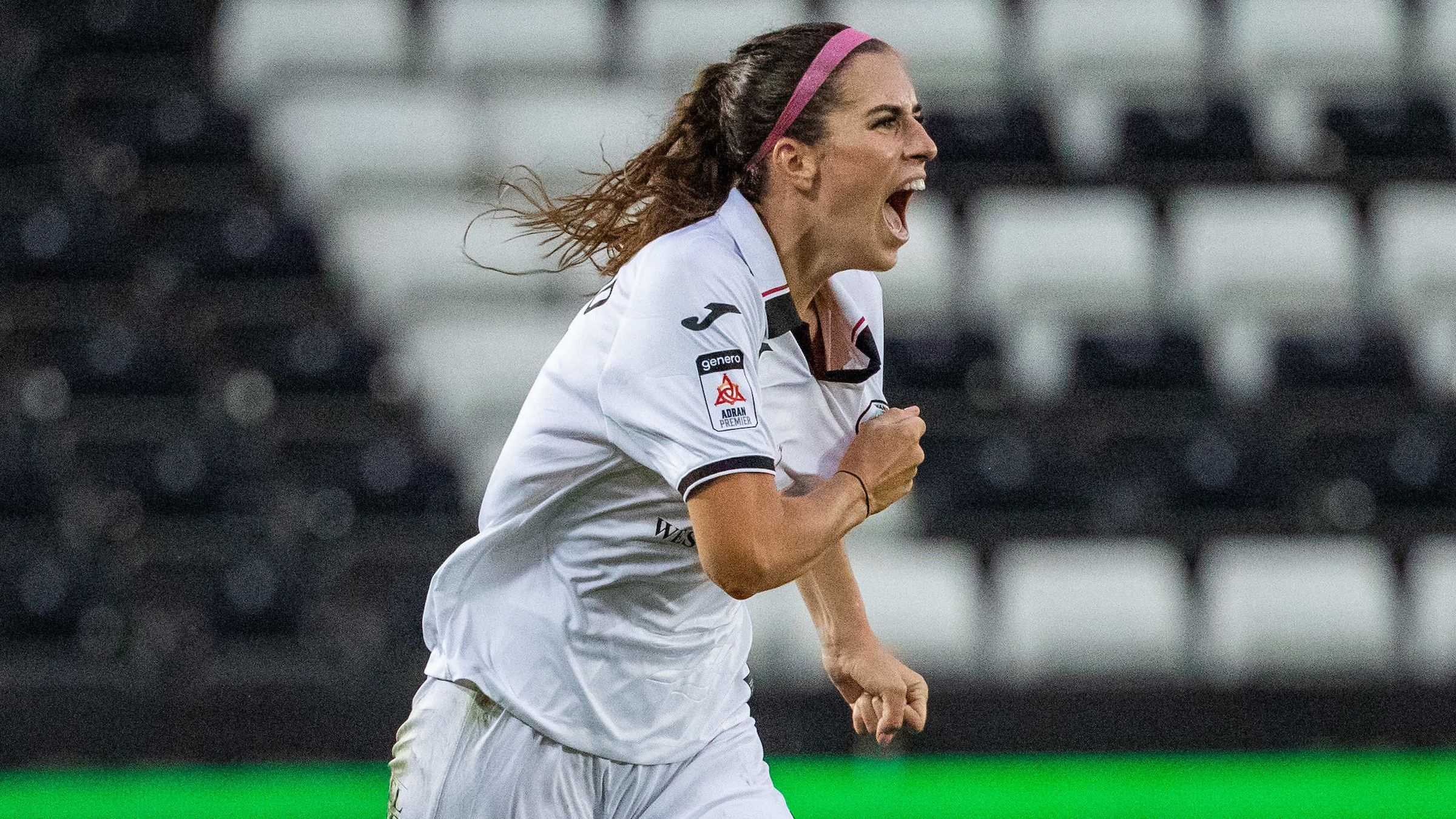 Katy Hosford celebrates by tapping the Swansea City badge on her shirt