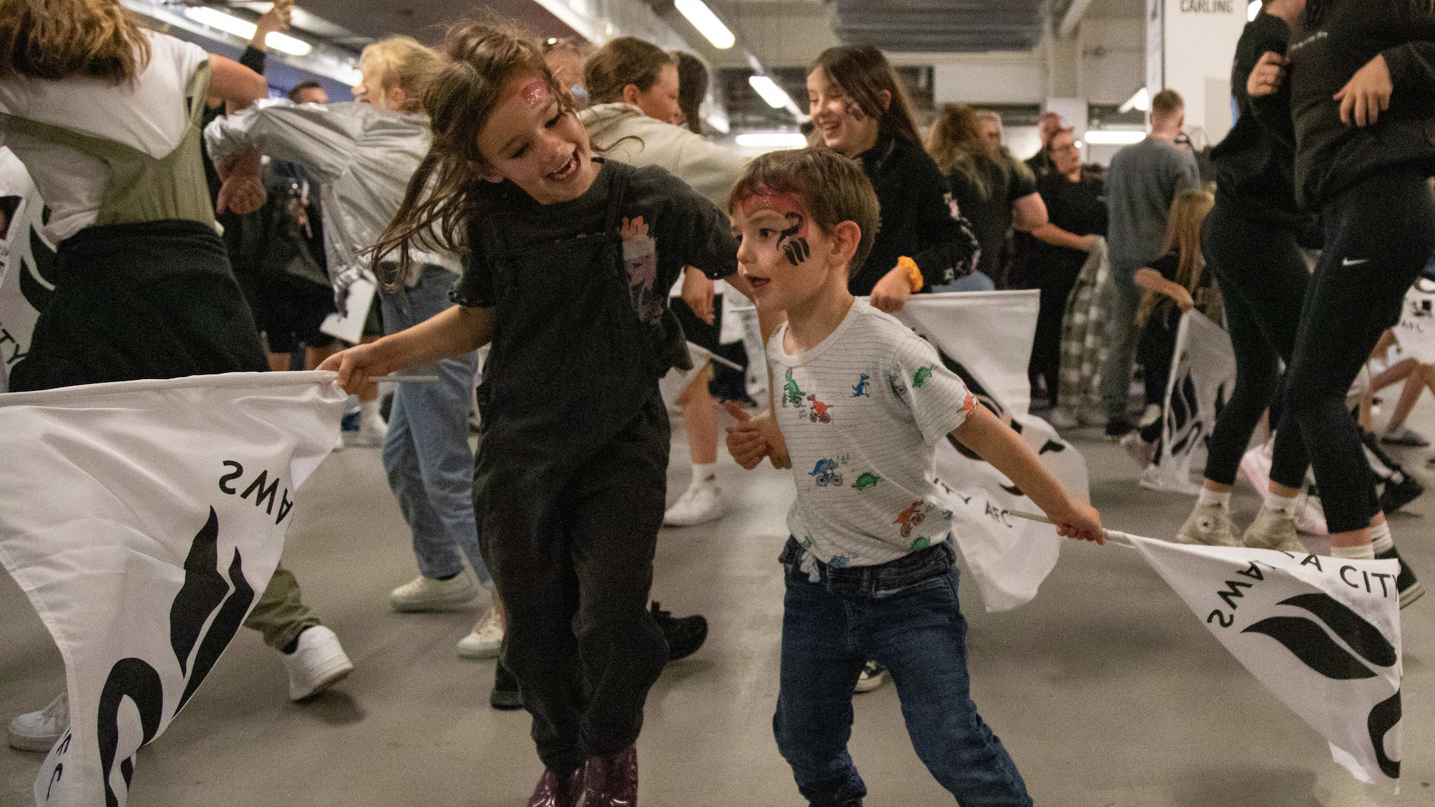 Two young fans dance during Swans game