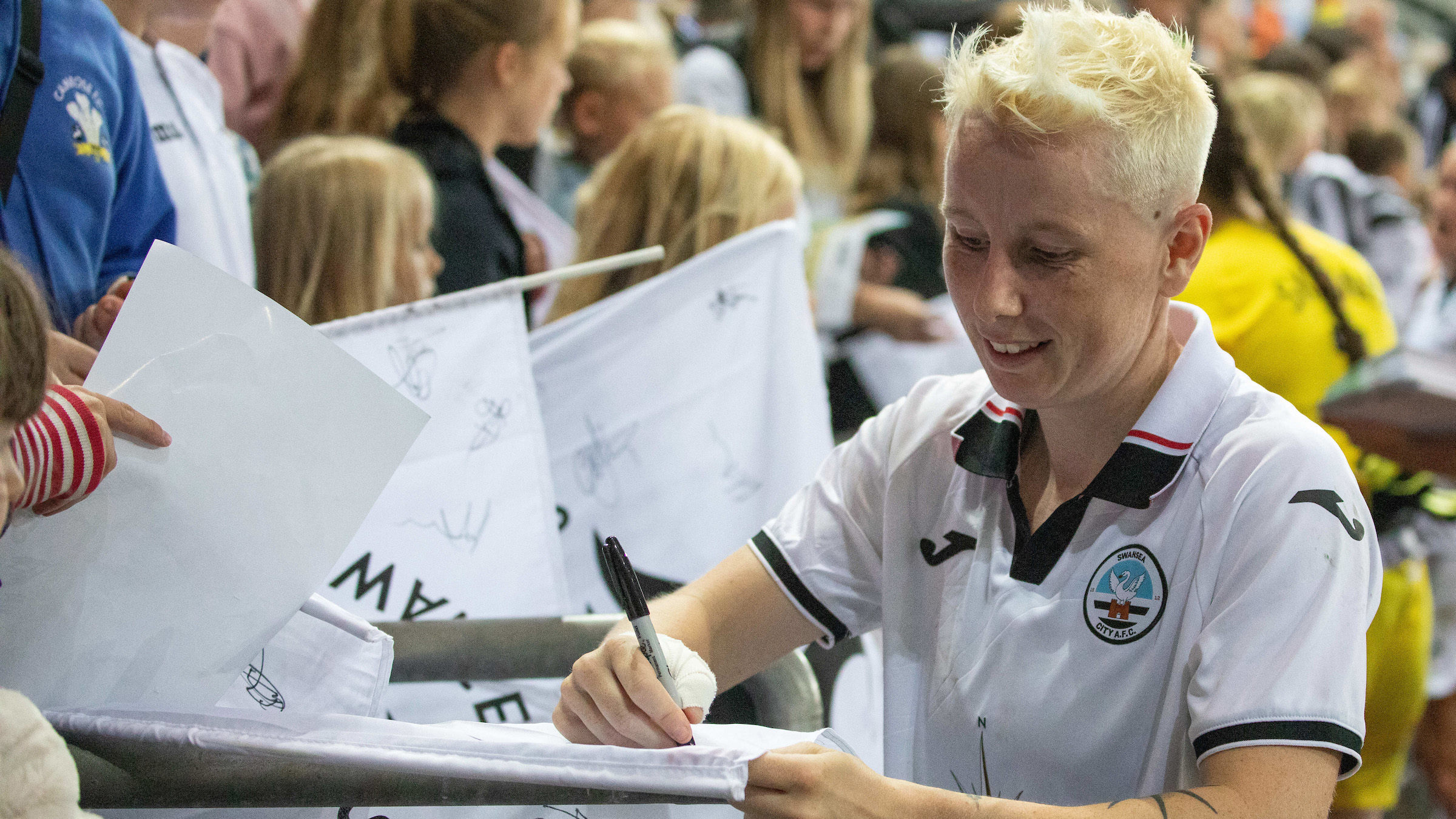 Stacey John-Davis signs an autograph for fans