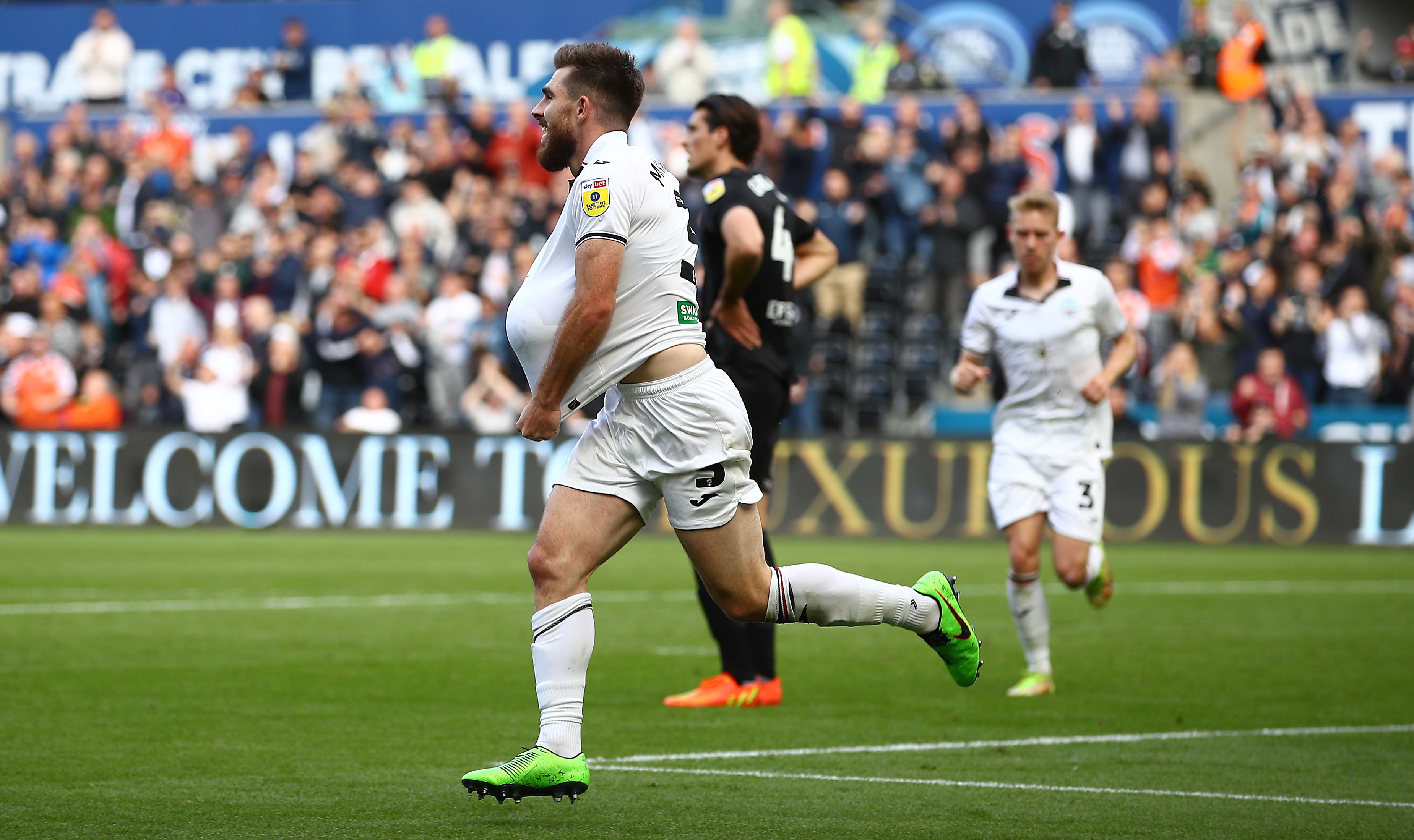 Ryan Manning celebrates by placing football under shirt