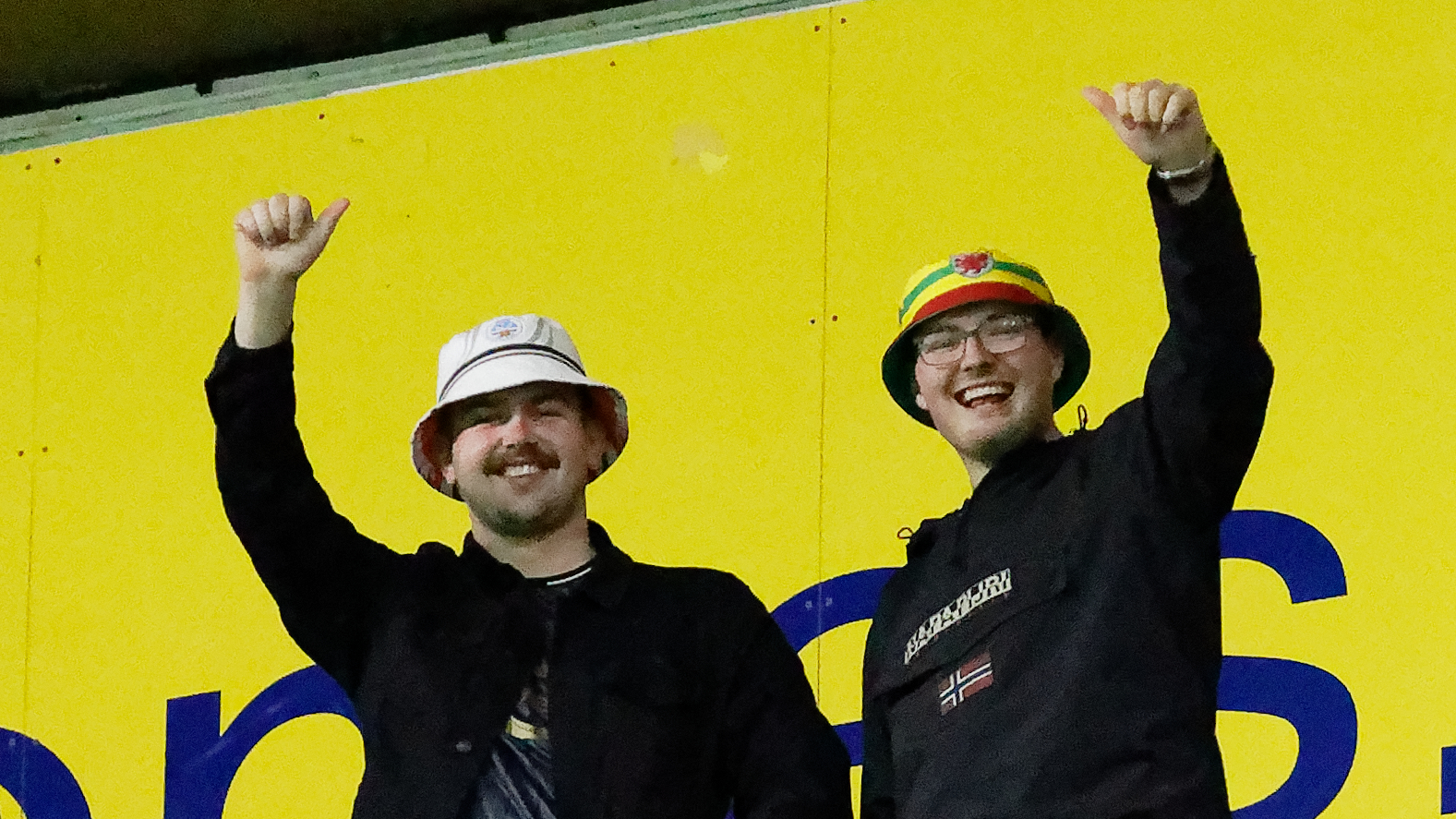 Two fans posing for the camera in the Preston North End away end