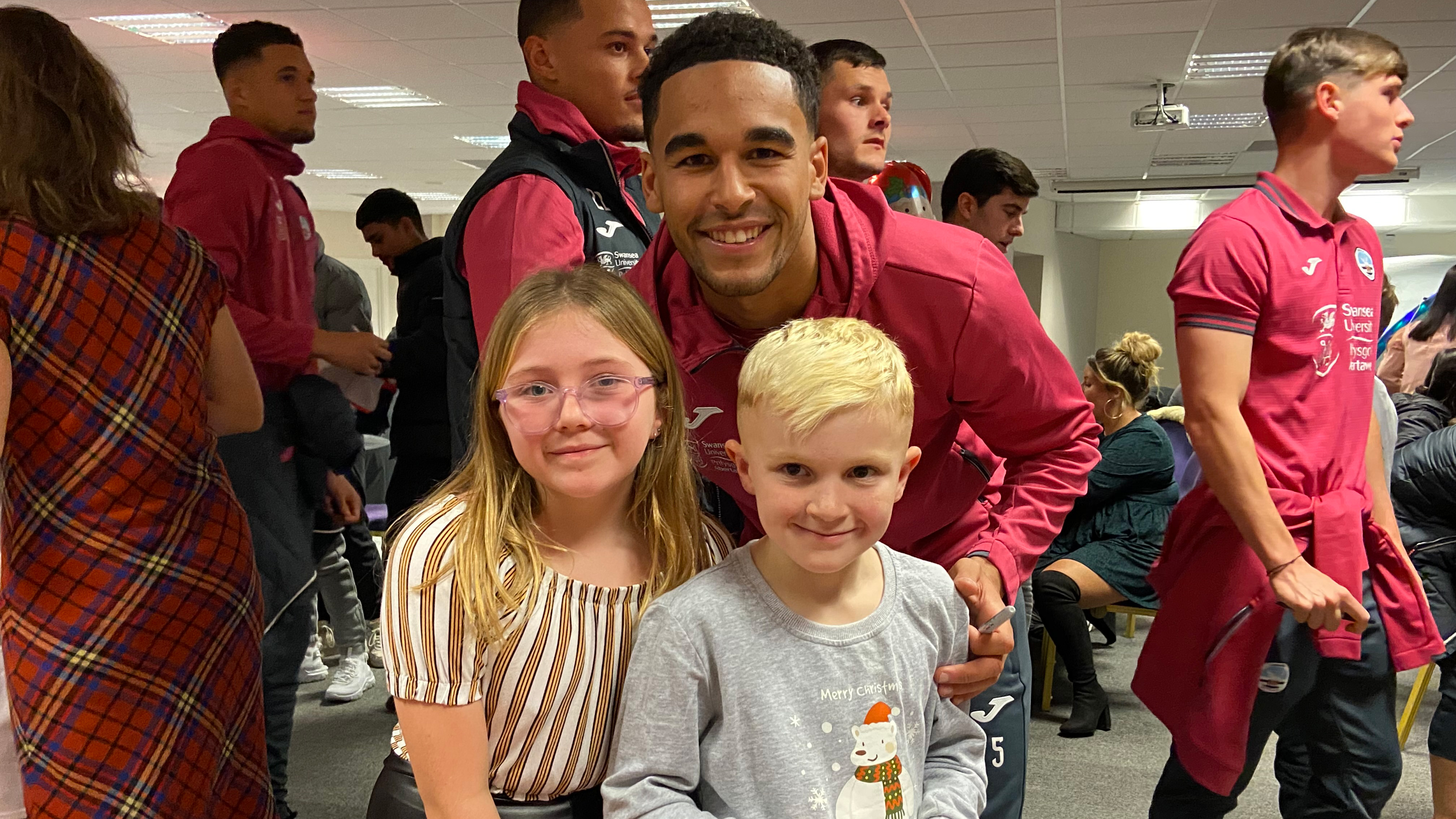 Ben Cabango poses for a photo with two young fans 