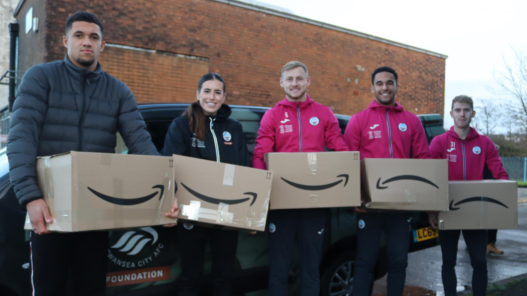 Nathan Wood, Katy Hosford, Harry Darling, Ben Cabango and Ollie Cooper hold hampers