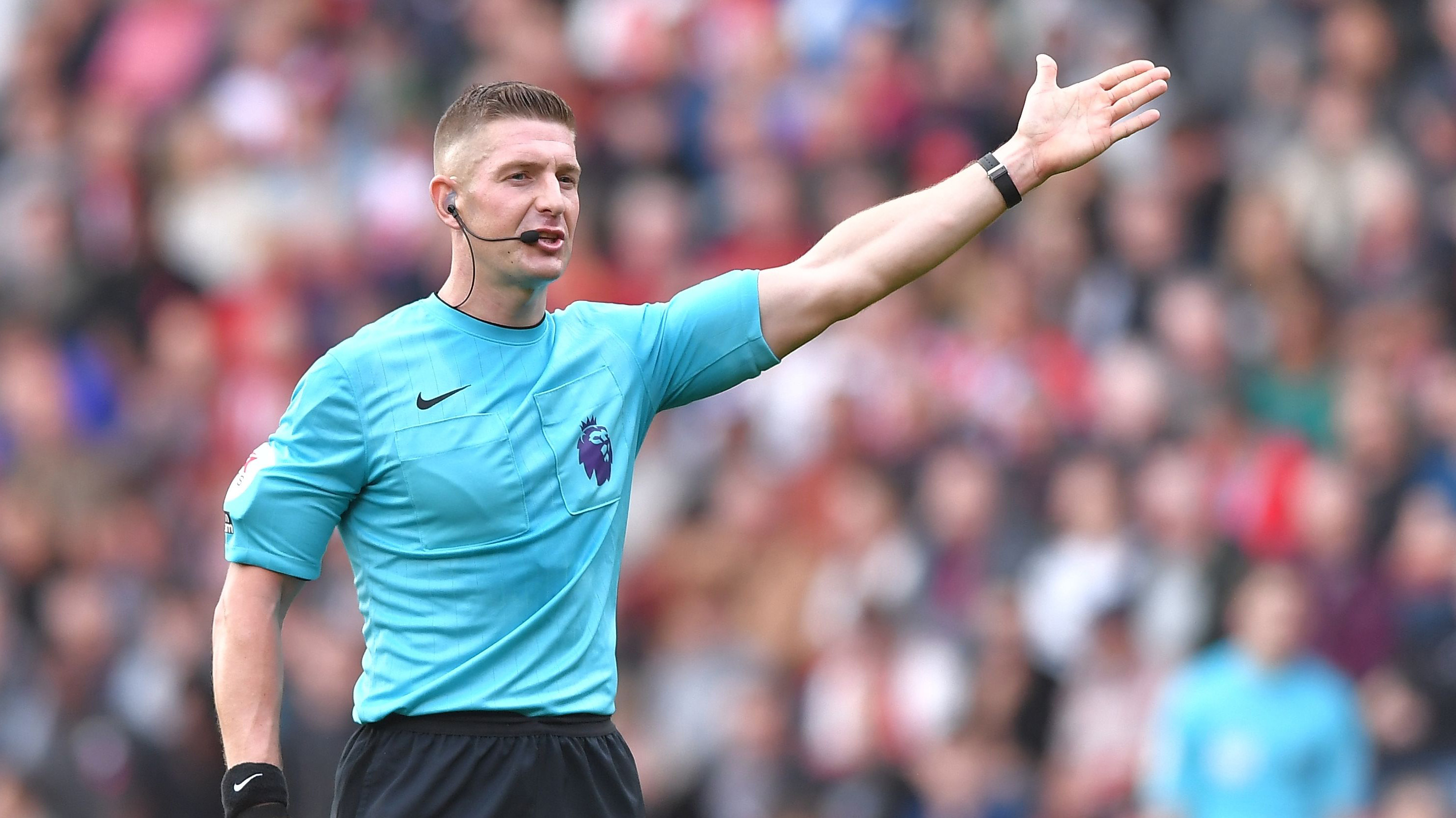 Referee Robert Jones signals for a free kick