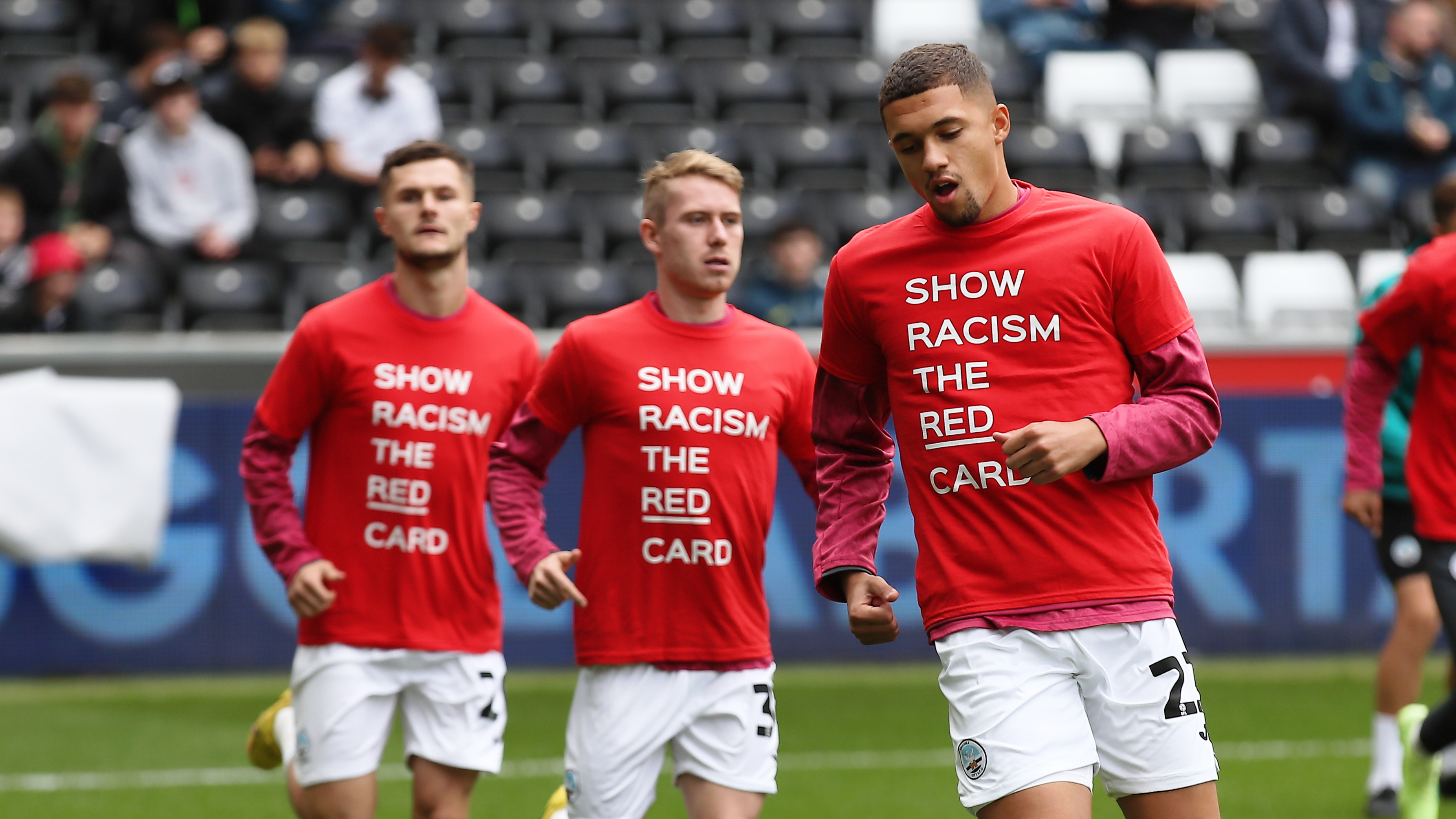 Nathan Wood, Ollie Cooper and Liam Cullen warm up in Show Racism the Red Card shirts