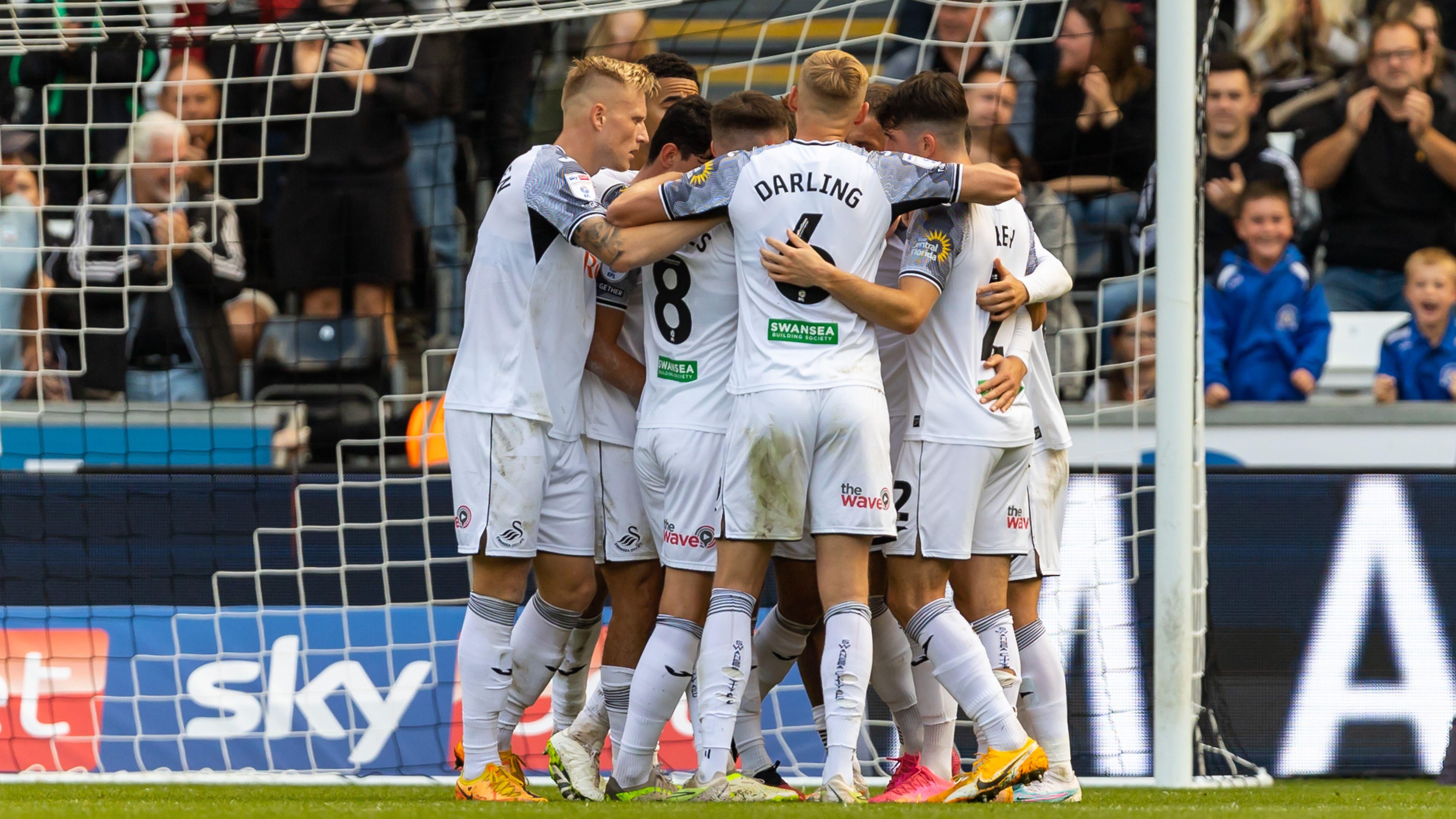 Swansea City team huddle as they celebrate goal against Wednesday