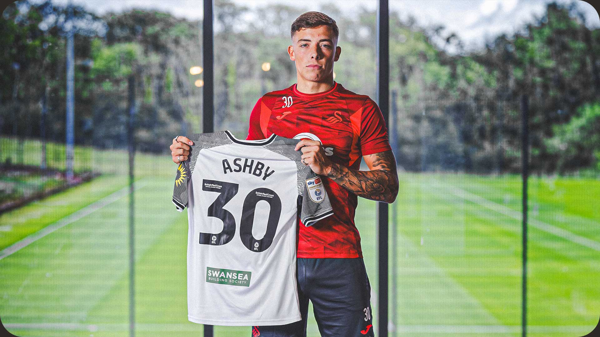 Photograph of Harrison Ashby holding the number 30 shirt.