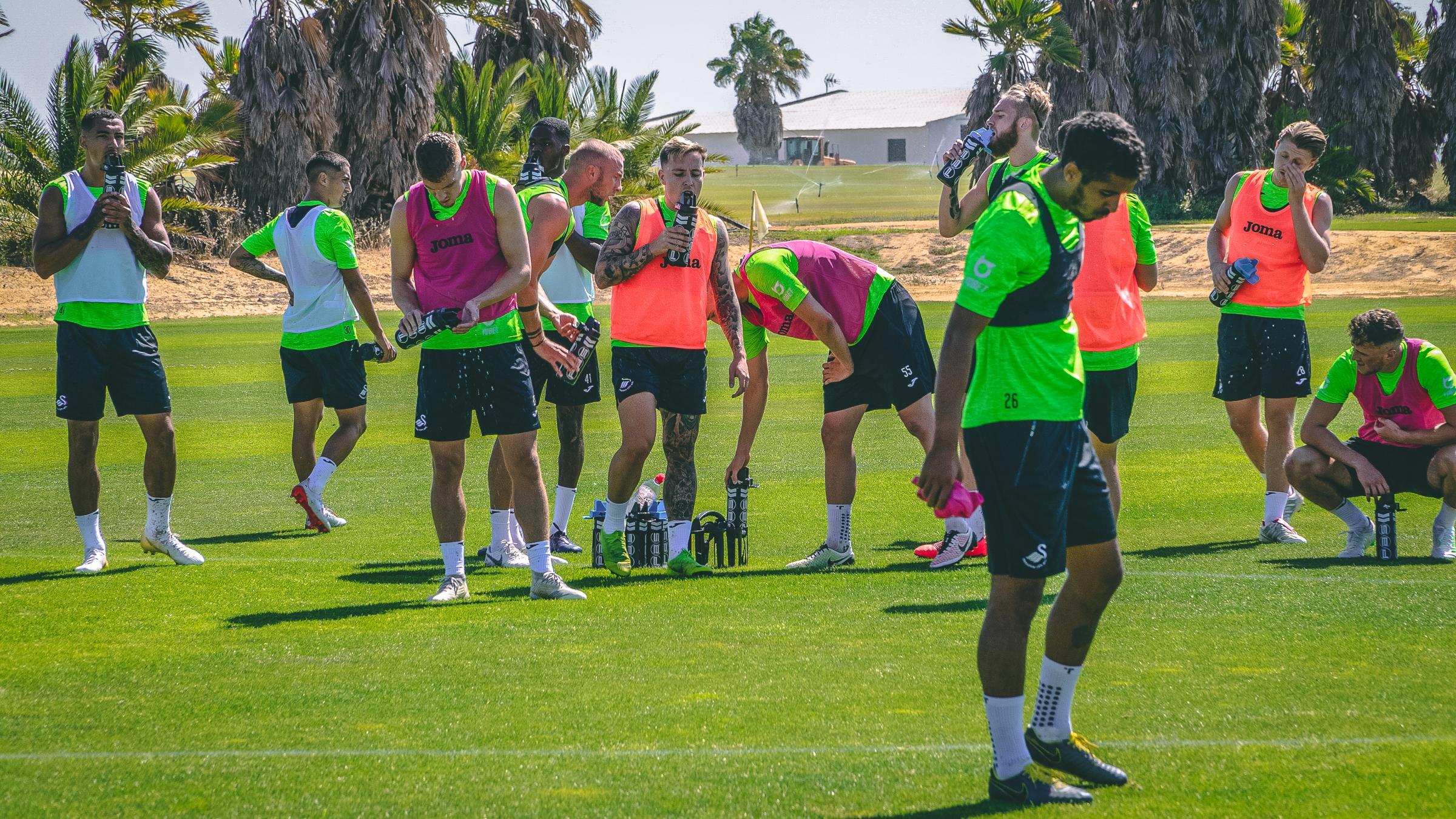 The squad take a brief drinks break during training.