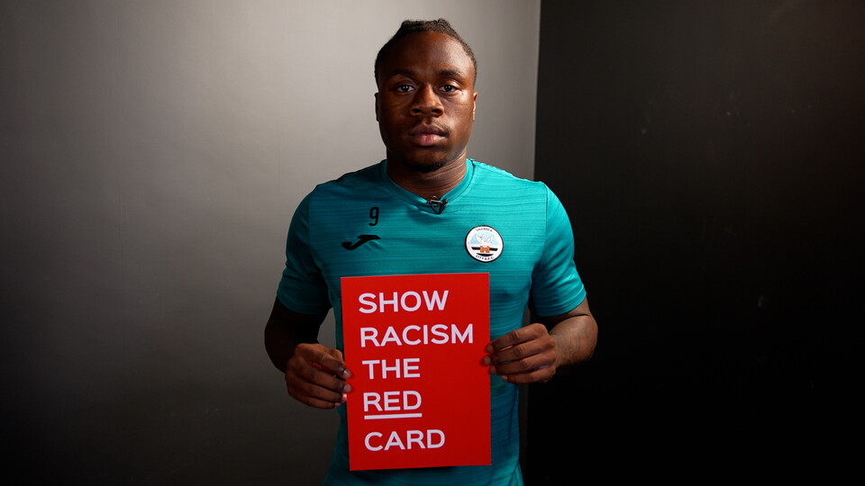 Michael Obafemi holds a show racism the red card card