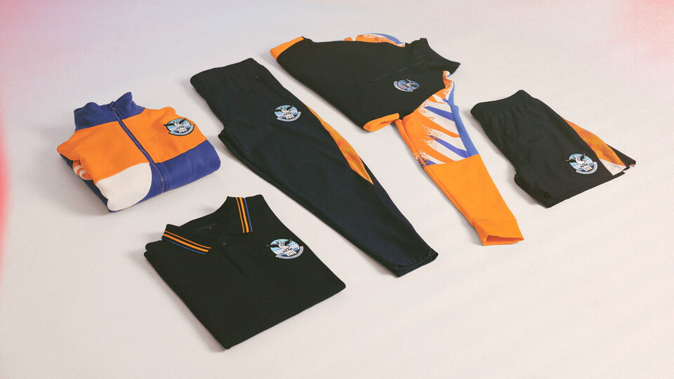 Five items of sports attire in black, orange, blue and white lay flat on a white background.
