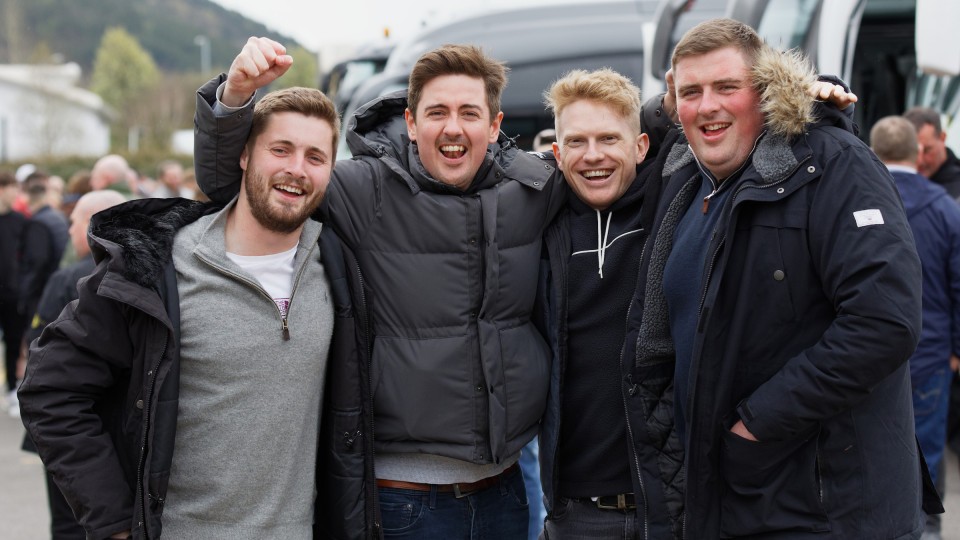 Group of Swansea fans in front of busses
