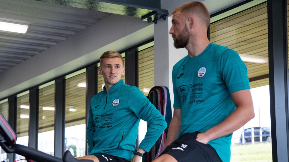 Flynn Downes and Brandon Cooper chat while on exercise bikes 