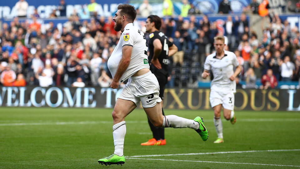 Ryan Manning celebrates by placing football under shirt