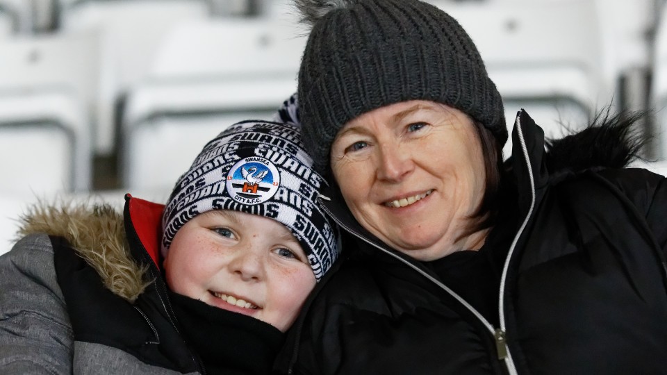 Mother and son pose for a photo while watching Swansea City v Blackpool