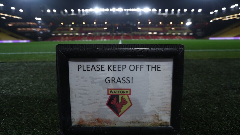 Watford stadium in the evening with keep off the grass sign