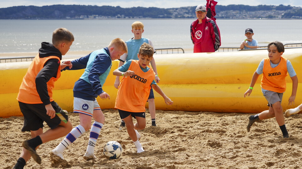 Junior Jacks play football on the beach