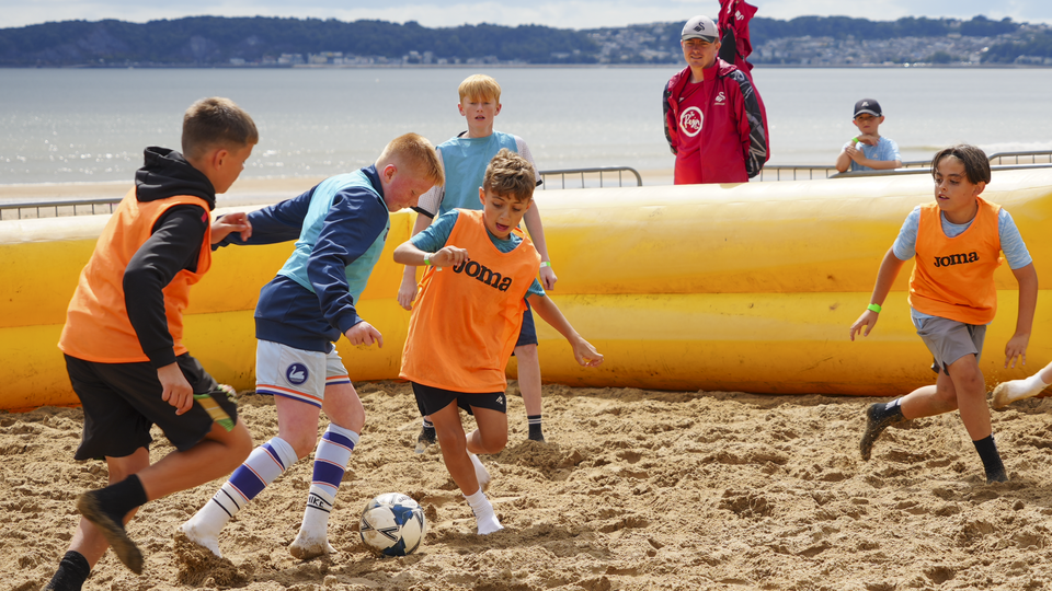 Junior Jacks play football on the beach