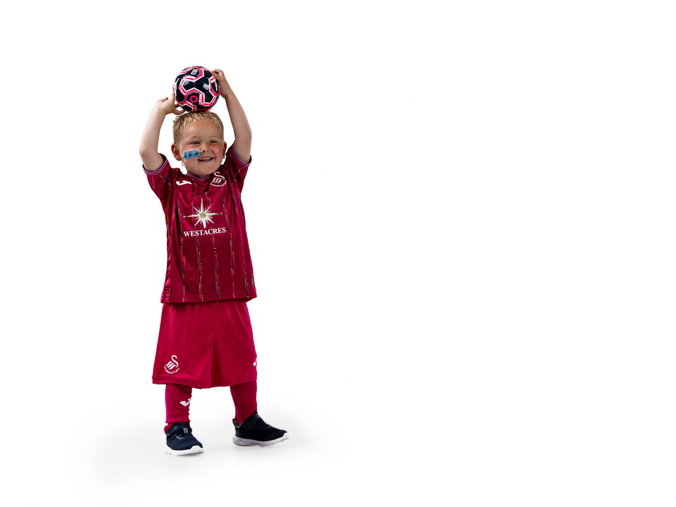 Photograph of Morgan Riddler, Smiling, Holding a Football, Wearing the Swansea City AFC Third Kit.