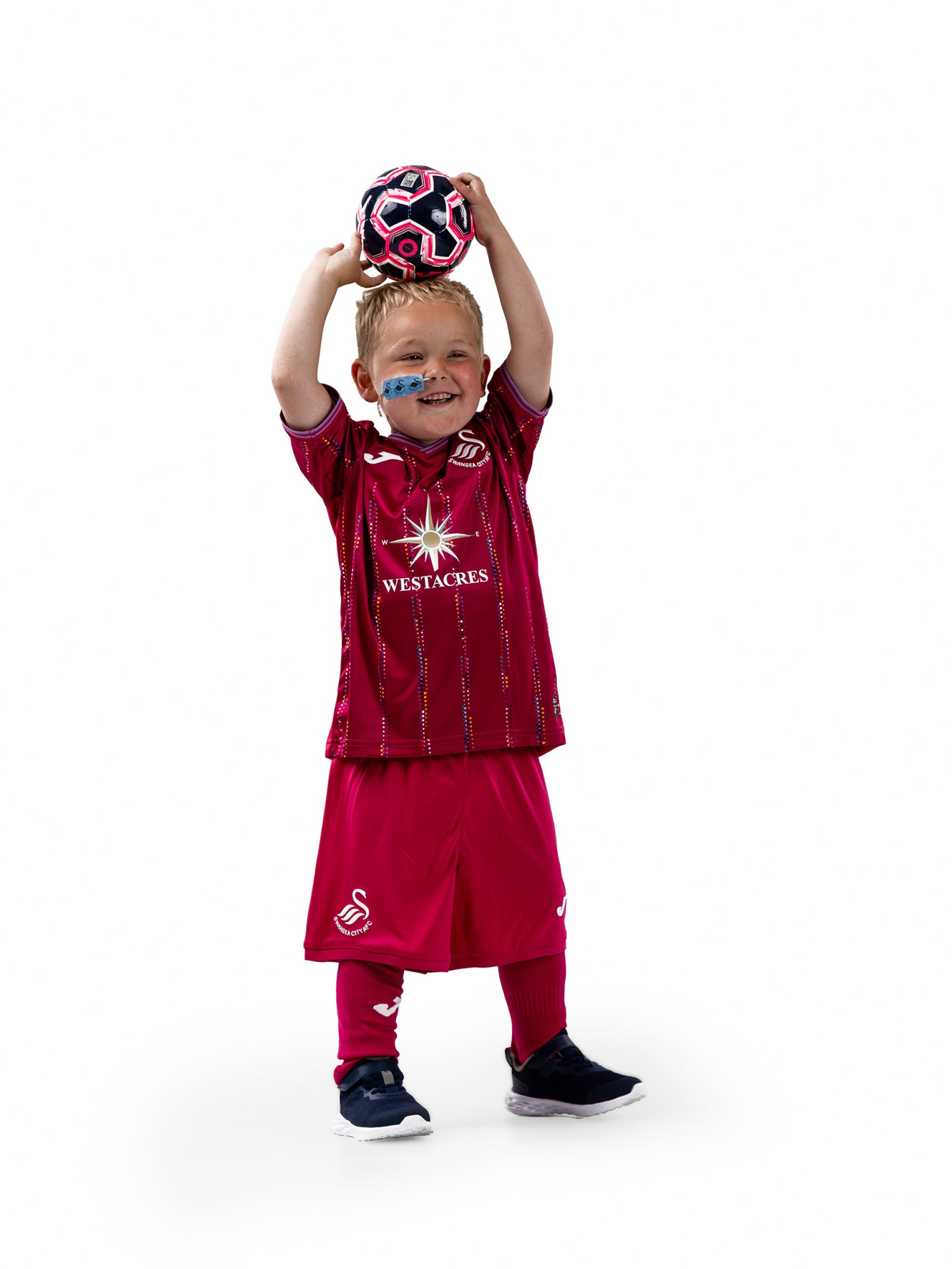 Photograph of Morgan Riddler, Smiling, Holding a Football, Wearing the Swansea City AFC Third Kit.